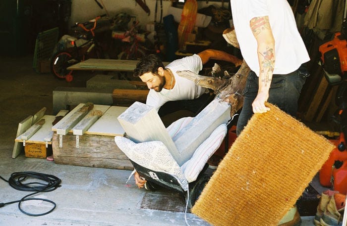 Hudson Valley artist Brad Teasdale lifting one of his half-concrete, half-wooden benches
