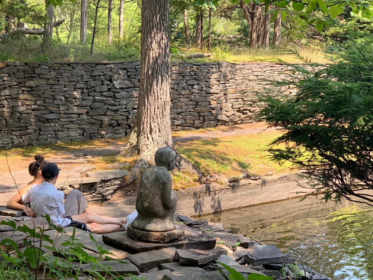 Two people sitting next to a water feature at Opus 40