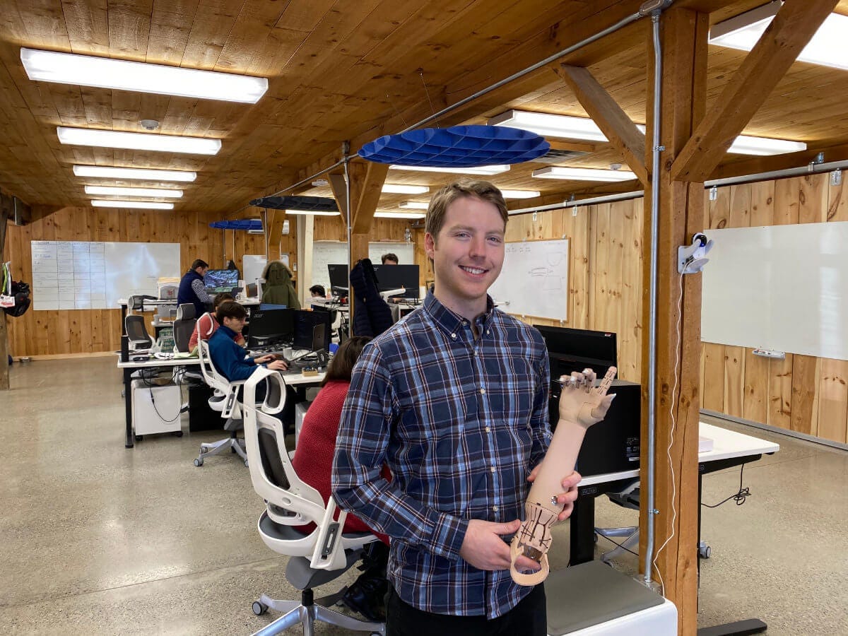 Easton LaChappelle holding a robotic hand at the Unlimited Tomorrow office in Rhinebeck NY