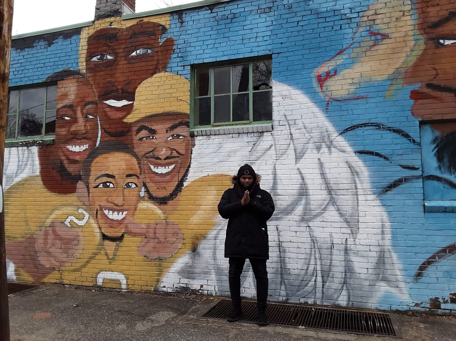 Jalani Lion in front of his first mural, on Franklin Street in Kingston.
