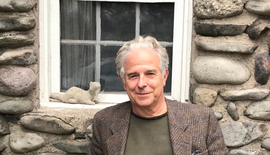 Author Neil Cohen in front of a stone house in the Hudson Valley